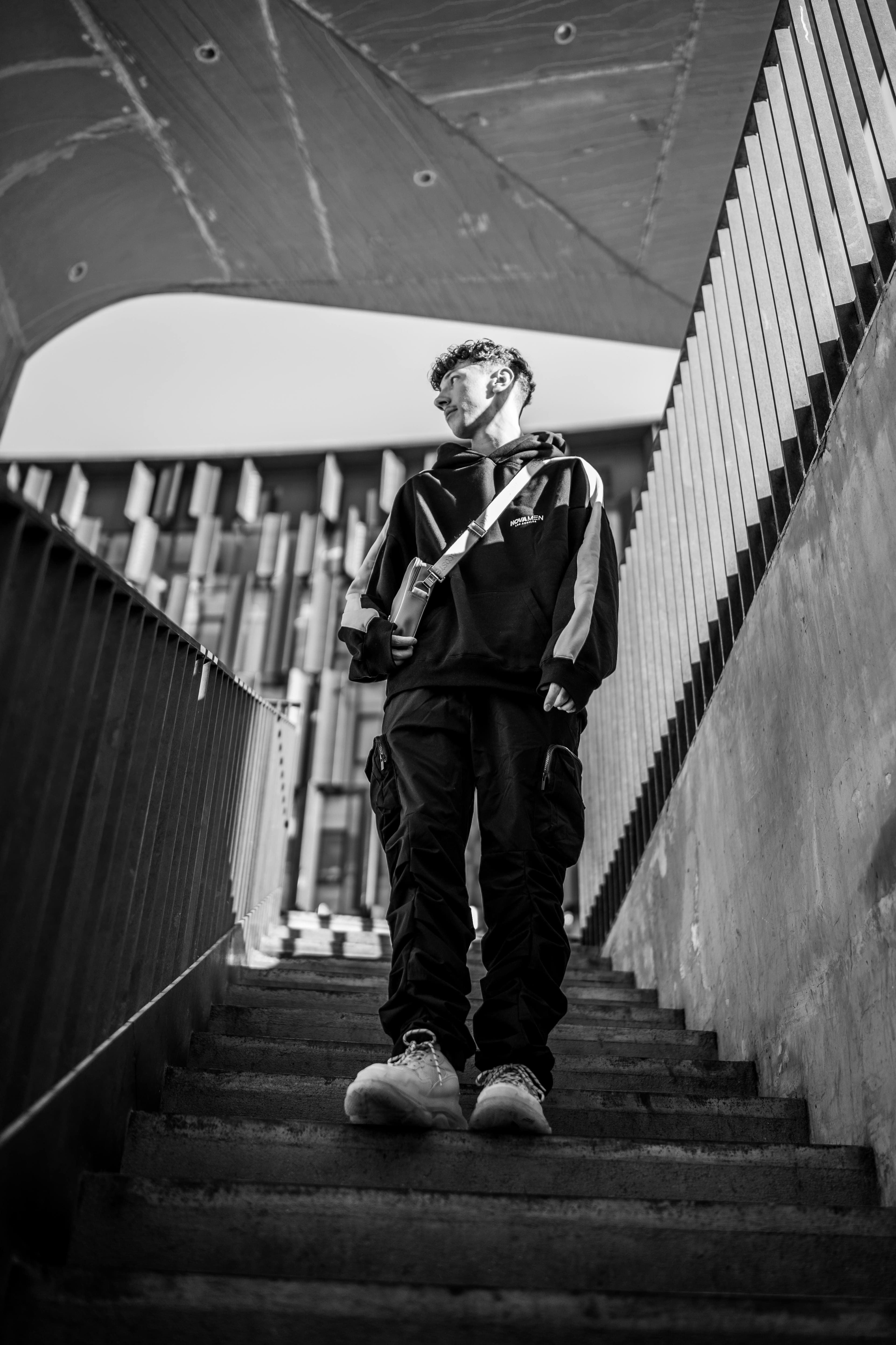 A young man in streetwear walking down a concrete staircase