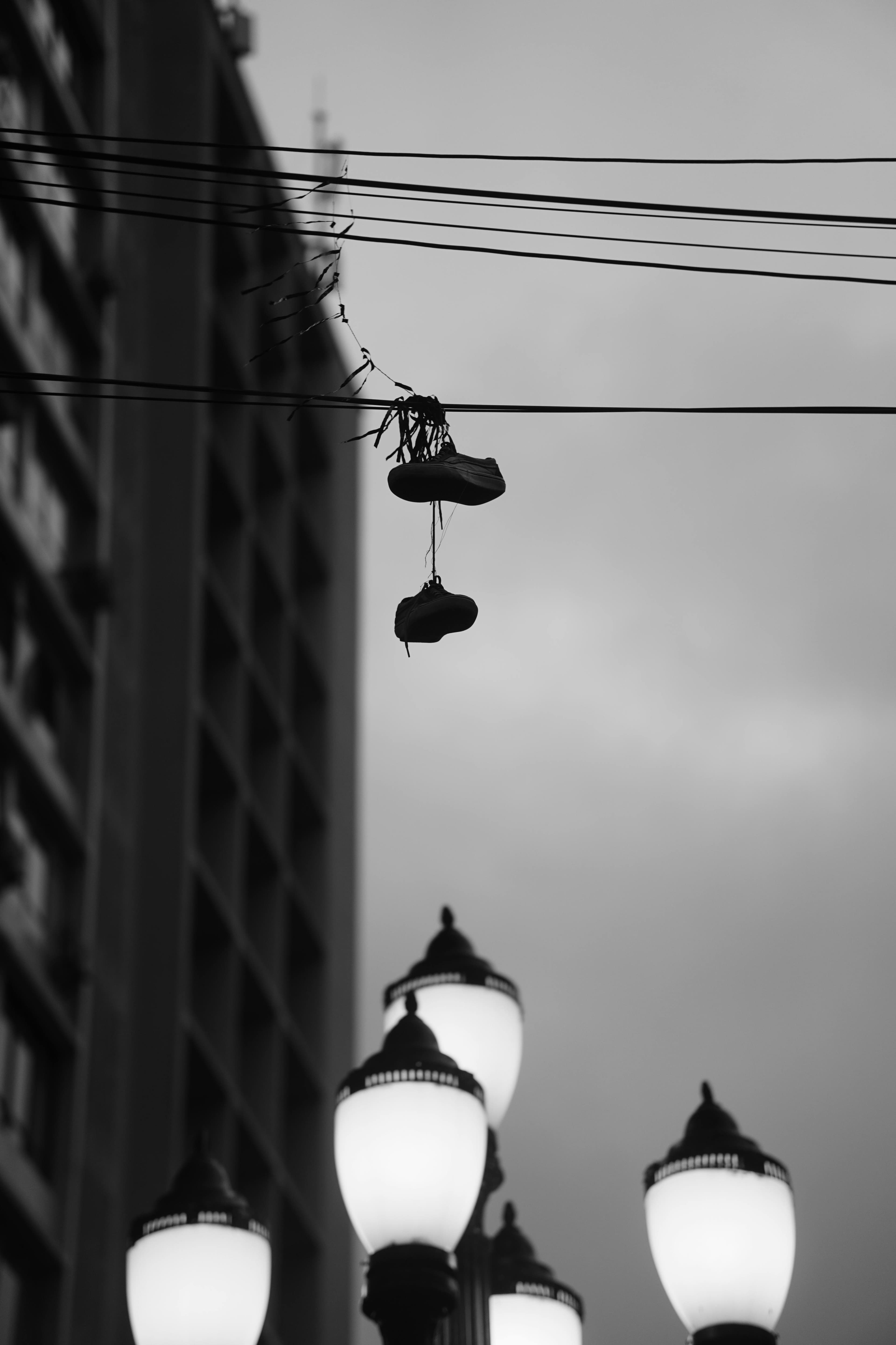 Sneakers hanging from a wire above a still-sleeping street